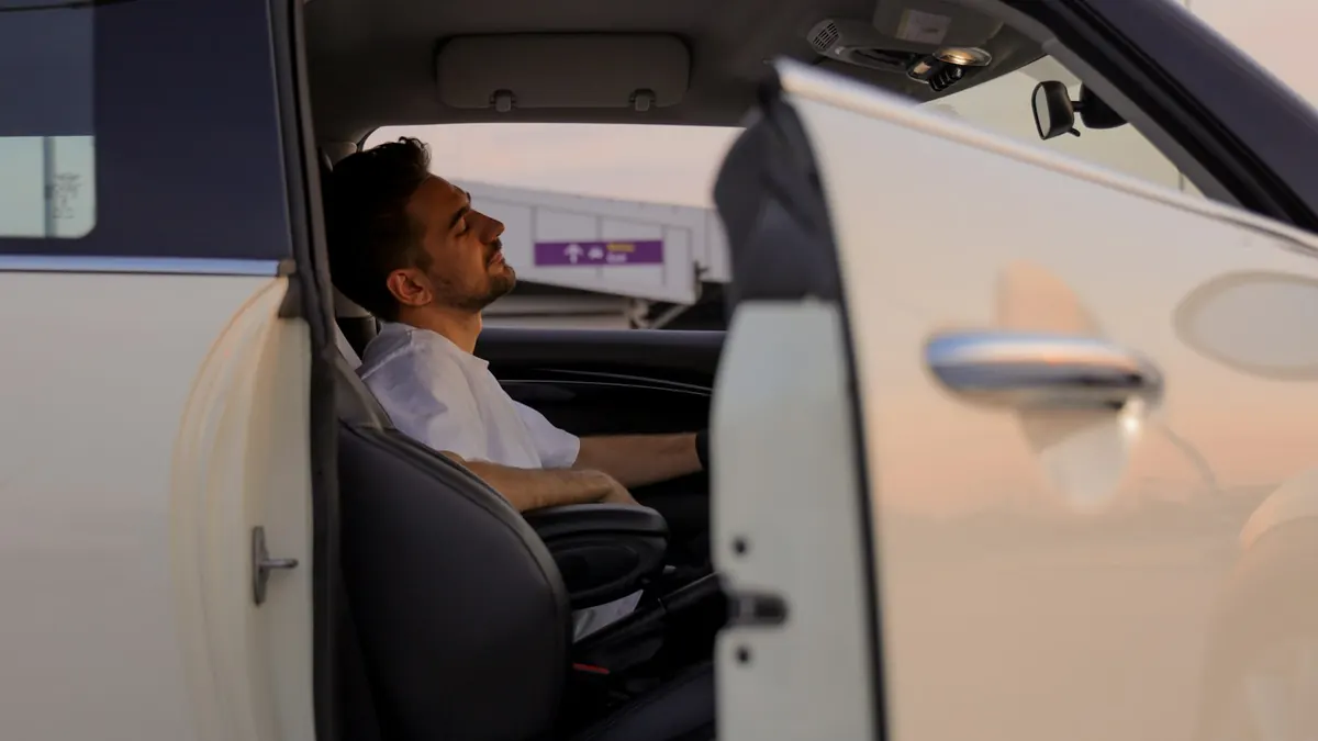 Chauffeur VTC installé au volant de son véhicule professionnel financé à crédit